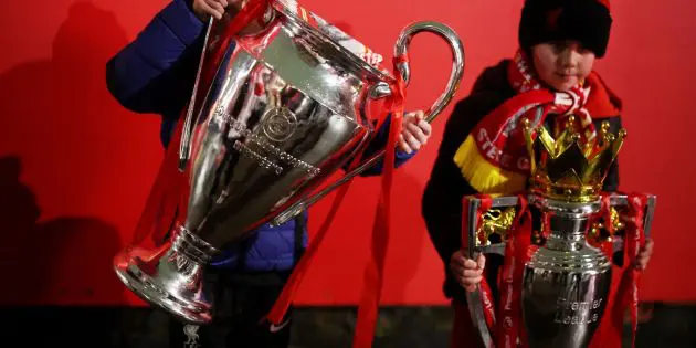 Liverpool fans with the Premier League and Champions League trophy