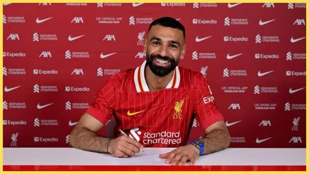 Mo Salah smiles whilst signing a contract extension.