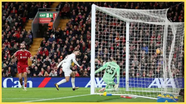 Adam Phillips of Barnsley scores his team's second goal past Giorgi Mamardashvili of Liverpool as teammate Dominik Szoboszlai reacts after making a defensive error